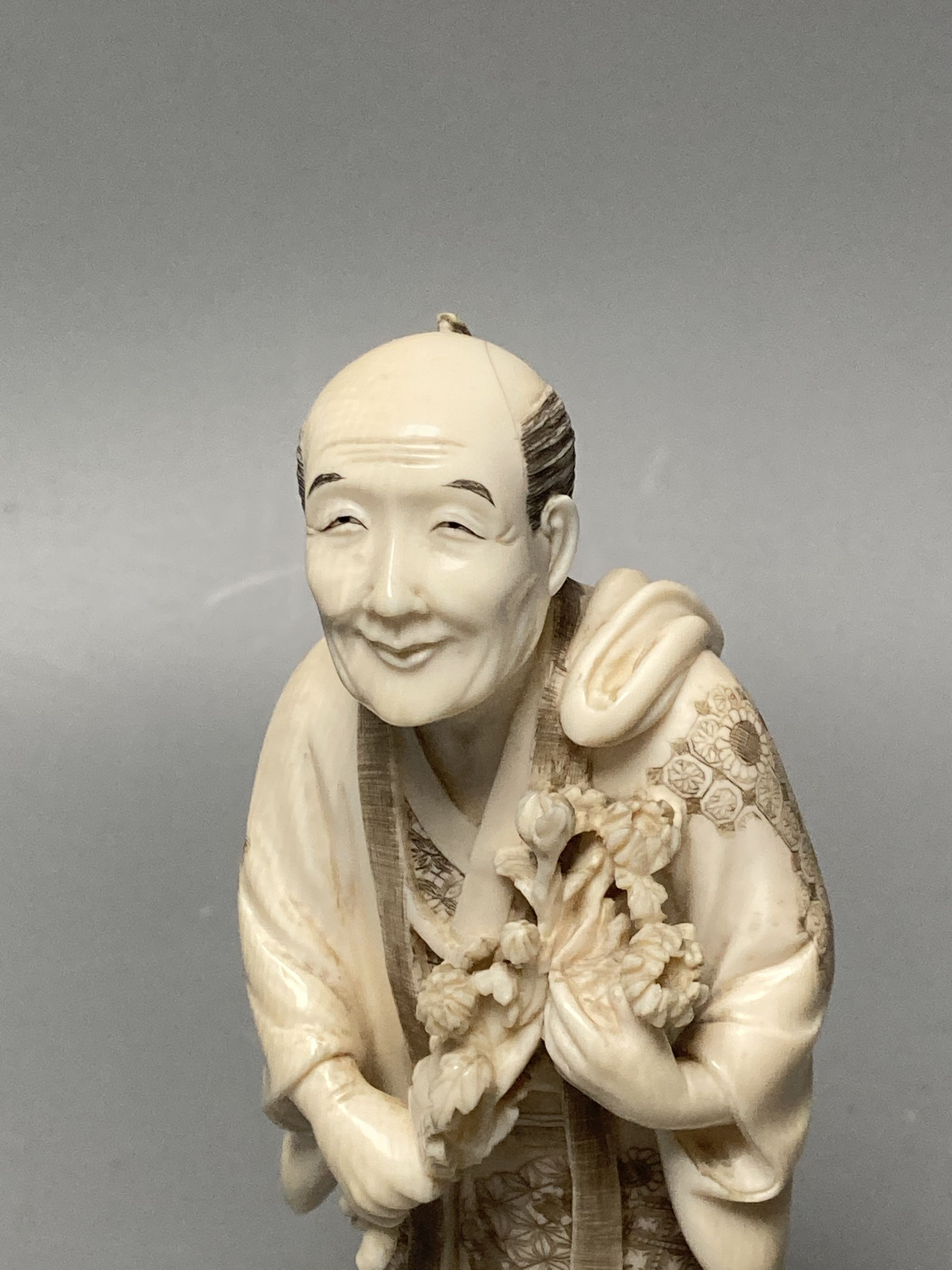 A Japanese ivory okimono of a man and dog, signed tablet to base, early 20th century, 19cm